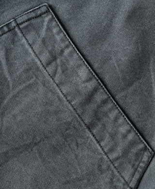 Gray-blue canvas jacket pocket edge with reinforced stitching