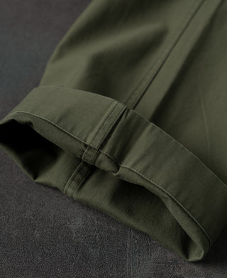Olive fatigue pants cuff with adjustable fold and clean hem stitching.