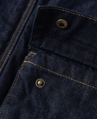 Indigo denim field jacket with snap button chest pocket detail.