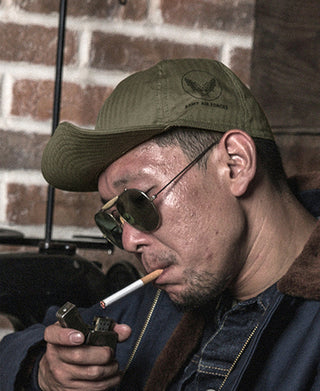 Man in an olive A-3 flight cap with Army Air Force emblem and sunglasses
