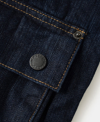 Indigo denim field jacket chest pocket with metal snap and topstitching.