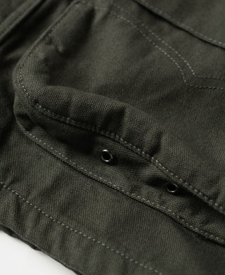 Olive canvas field jacket sleeve cuff with buttoned strap and stitched details