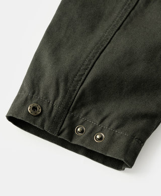 Olive canvas field jacket hem with side buttons and buttoned cuff end