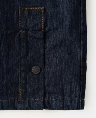 Indigo denim field jacket side pocket with flap and metal button.