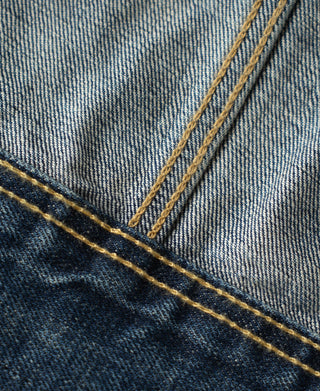 Indigo denim jacket collar seam with yellow double-needle topstitching