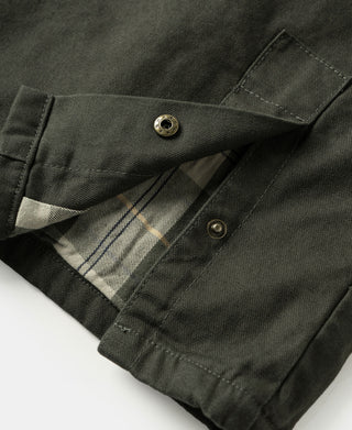 Olive canvas field jacket sleeve lining showing plaid fabric inside