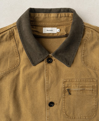 Khaki jacket close-up showing dark collar, buttons, and zippered chest pocket