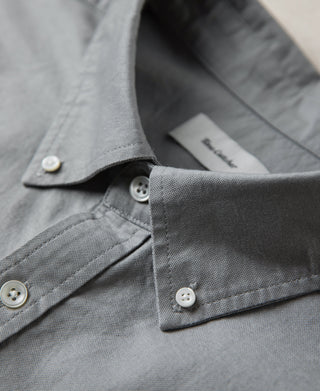 Gray button-down shirt collar with white buttons and inner label