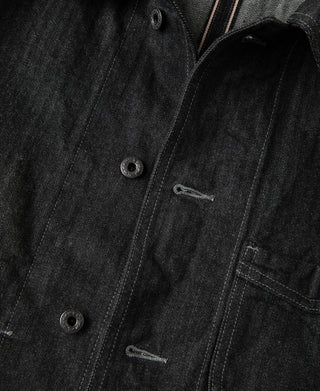 Black denim jacket close-up of button placket and right chest pocket