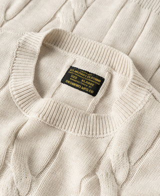 Crewneck collar detail on apricot cable knit sweater with brand label
