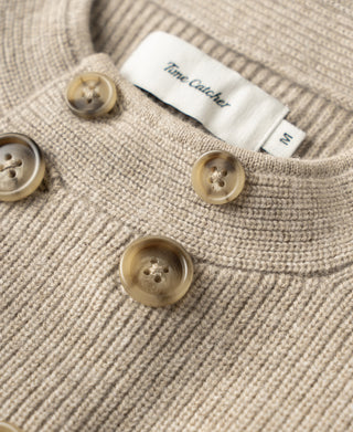 Ecru knit cardigan detail: fabric texture and round button placket