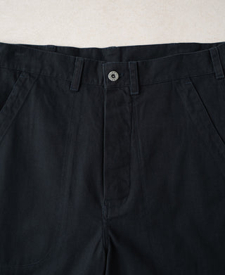 Navy deck trousers waistband with button closure, belt loops, and round insignia