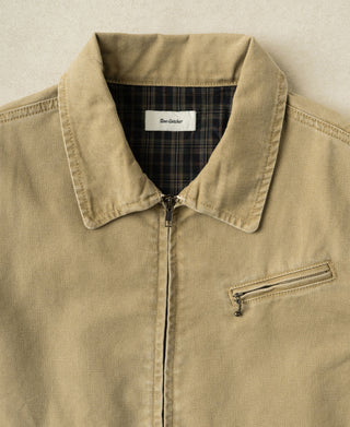 Washed khaki cossack jacket chest detail: plaid collar, center zipper, and front coin pocket