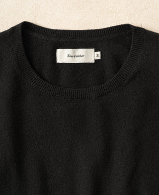 Black crewneck sweater neckline with ribbed trim and brand label