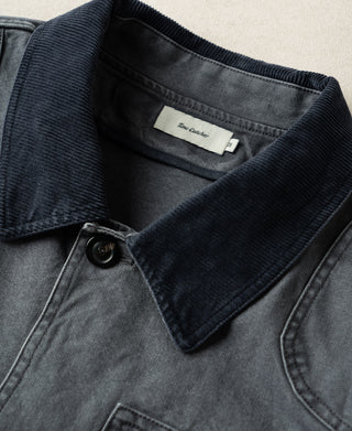 Gray-blue jacket close-up showing dark corduroy collar and top button