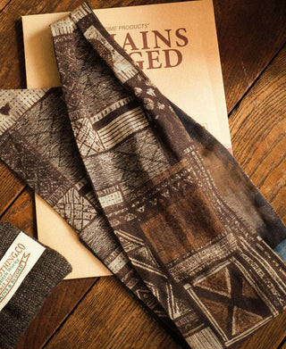 Close-up of the scarf's brown and cream geometric print with blue accents.