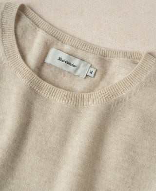 Apricot crewneck sweater neckline with ribbed trim and inner label.