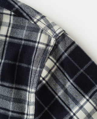 Blue check work shirt fabric close-up with woven grid pattern and seam detail