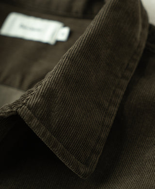 Close-up of rosin green cotton corduroy shirt cuff with button and ribbed trim