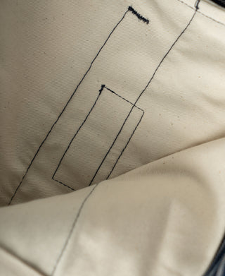 Striped trouser fabric close-up with contrast stitching and folded seam
