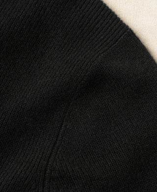 Black knit cardigan side seam close-up with subtle ribbed texture