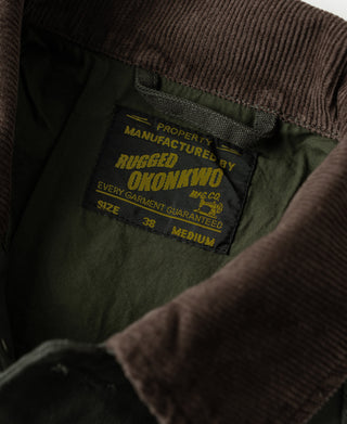 Olive jacket inner label and brown corduroy collar seam detail