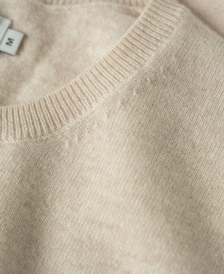 Apricot merino wool crewneck with ribbed collar and knit texture detail.