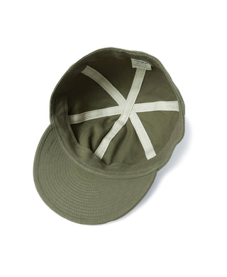 Olive A-3 flight cap with crossed white accent straps on the front