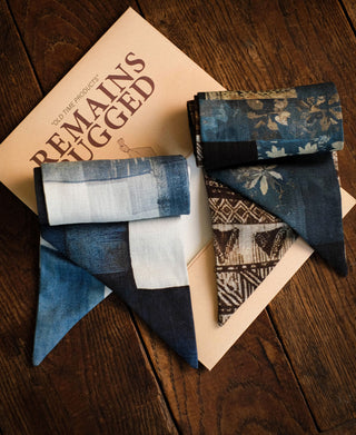 Two printed neck scarves folded to show geometric and floral blue and brown patterns