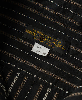 Shirt neck label and size tag against the black striped fabric