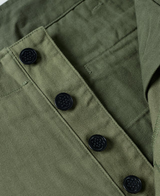 Olive fatigue trousers leg with buttoned placket and decorative dark buttons
