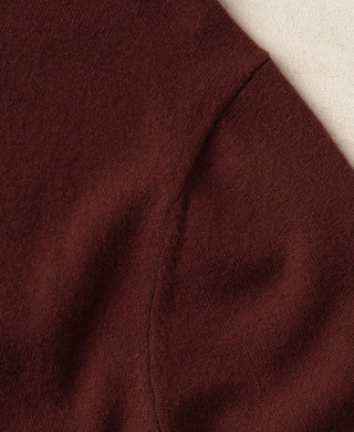 Maroon knit sweater sleeve with ribbed cuff and side seam