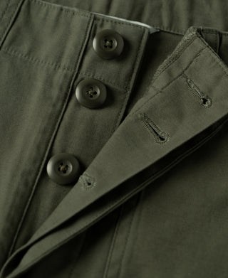 Olive fatigue pants waistband detail with button fly and hidden front facing.