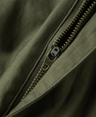 Close-up of olive trouser zipper fly with metal teeth and fabric seam