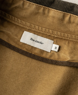 Khaki canvas field jacket collar with Time Catcher label and size M tag