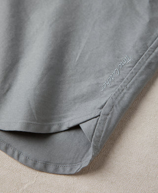 Gray oxford shirt hem with brand-embroidered detail and stitched edge