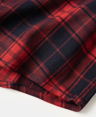 Red and dark navy plaid fabric texture on heavyweight work shirt hem with stitched edge