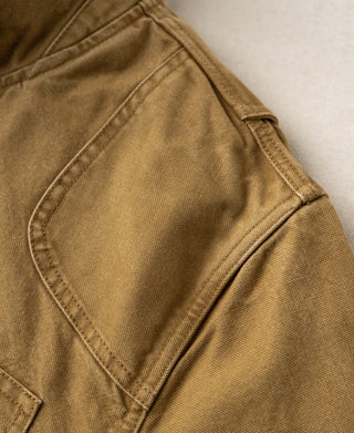 Khaki canvas field jacket with a large stitched pocket panel
