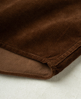 Brown corduroy shirt hem with ribbed texture and stitched edge