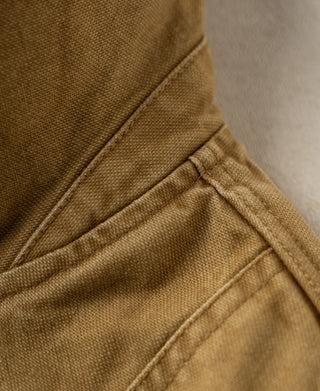 Khaki canvas field jacket with close-up of a pocket seam