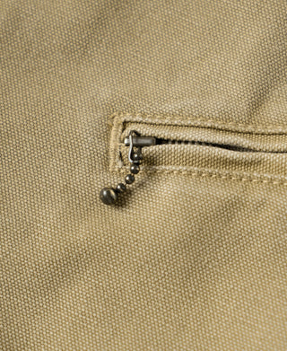 Washed khaki jacket zipper pull detail with small metal ring and braided trim