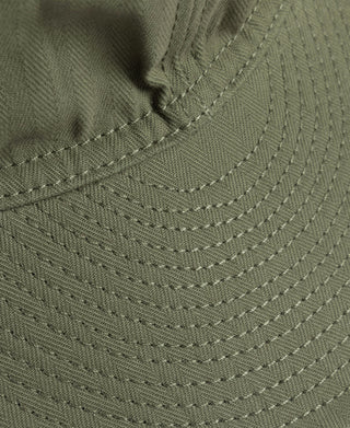 Olive A-3 cap close-up of curved stitched brim and side seam stitching