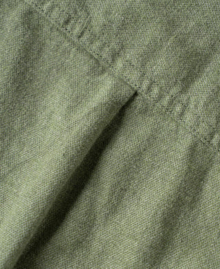 Sage brushed cotton flannel fabric close-up with stitched seam lines