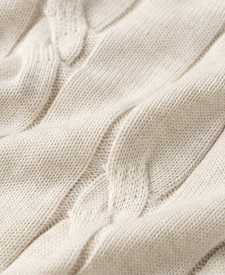 Close-up of apricot cable knit sweater texture with vertical cable stitches