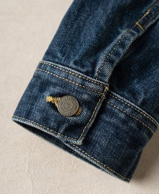 Indigo denim sleeve cuff with metal button and contrast topstitching