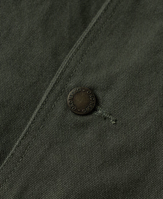 Olive jacket corner detail with round metal snap and reinforced stitching