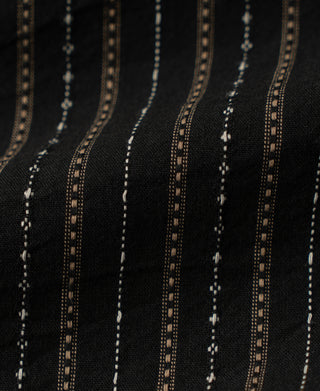 Close-up of black jacquard fabric with fine tan and white stripes