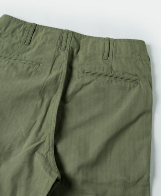 Olive fatigue trousers close-up of side pocket and front seam details