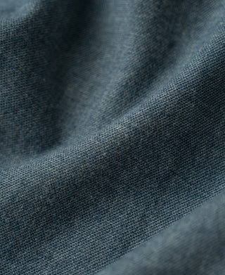 Close-up of blue brushed cotton flannel fabric texture with woven speckled pattern.