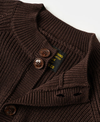 Detailed view of wooden buttons and textured knit fabric on a brown wool-blend cardigan sweater.